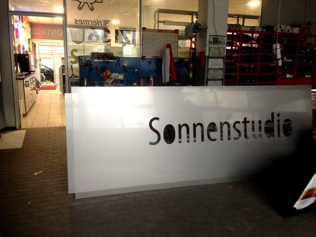 SUN TROPEZ Sonnenstudio Aussenwerbung bei Nacht, effektvolle Beleuchtung.