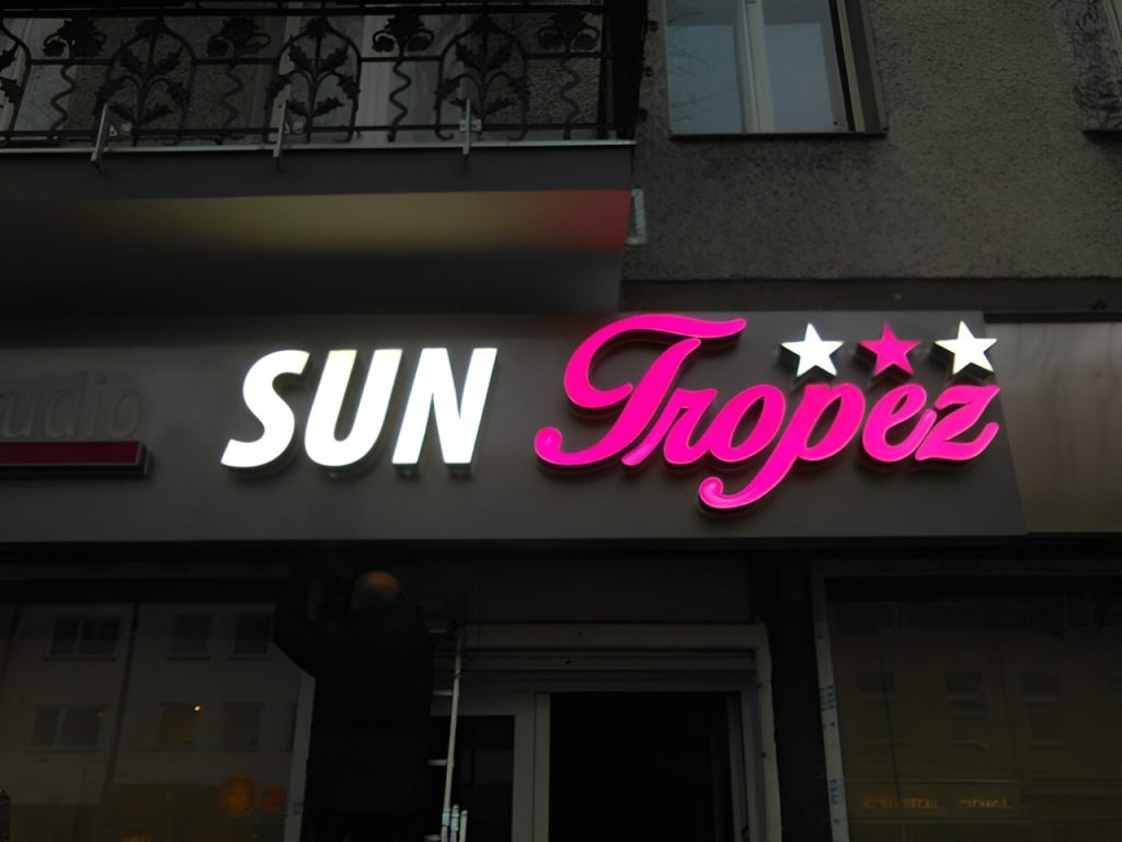 SUN TROPEZ Logo Leuchtreklame Detail bei Nacht, strahlendes Designelement.